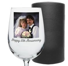 a wine glass with an image of a bride and groom on it next to a canister