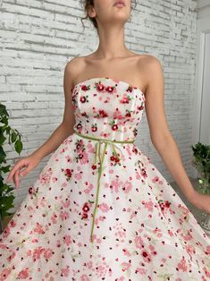 Enjoy long days and short nights in the Tulip Fields Gown. With a mesh-net fabric and a straight neckline, you can feel the warm summer wind on your skin. Embroidered with miniature flowers and crystal leaves so you can live in a blossoming garden... Summer Tulle Gown With Floral Embroidery, Spring Gown With Floral Applique And Fitted Bodice, Strapless Tulle Gown For Spring, Spring Strapless Tulle Gown, Spring Floral Print Prom Gown, Floral Print Prom Gown For Spring, Organza Gown For Garden Party, Spring Gown With Floral Embroidery And Sweetheart Neckline, Spring Organza Gown With Floral Embroidery