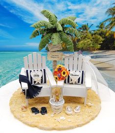 two beach chairs and a palm tree on the sand