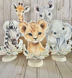 three paper cutouts of different animals in front of a wooden background with white wood planks