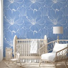 a baby's room with blue wallpaper and white crib in the corner