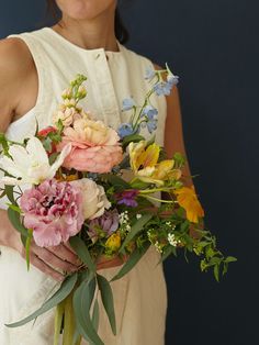 a woman holding a bouquet of flowers in her hands