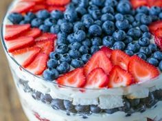 a trifle with blueberries, strawberries and other fruit on top is shown