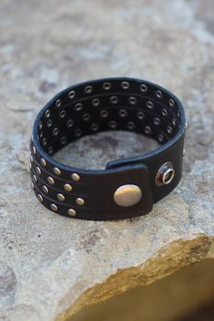 This studded cuff gives the illusion you are wearing four studded bracelets! -Color: Black -Handmade -Genuine leather -Measurements: 9"L -Imported Punk Black Bracelet With Silver Studs, Black Edgy Wristband With Studs, Black Leather Punk Bracelet With Silver Studs, Punk Cuff Bracelets With Rivets, Edgy Black Cuff Bracelet With Rivets, Edgy Leather Bracelets With Studs, Black Leather Bracelet With Studs, Edgy Leather Bracelet With Studs, Edgy Black Leather Bracelet With Studs