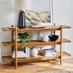 a wooden shelf with books and vases on it