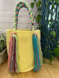 Description:  Cute Pastel Green & Pink Top Handle Bag These Boho bag was 100% hand knit by Wayuu Women but designed by us. The Wayuu are an indigenous tribe in Colombia known for their beautiful handwoven work, and this bag represents about a week's worth of work. Details: Handmade item - Handwoven Color: Yellow, Pink, Green, & Blue  Material: 100% Acrylic Width: 11" Height: 11" Total Length: 20" Materials: Nylon, Cotton Style: Boho Chic/ Flirty/ Kawaii/ Hippie Chic/ Trendy Check out other simil Playful Shoulder Bag With Large Capacity For Daily Use, Cute Multicolor Rectangular Shoulder Bag, Trendy Multicolor Handheld Bucket Bag, Cute Multicolor Bags For Daily Use, Multicolor Handheld Bucket Bag With Handles, Playful Bags With Adjustable Strap For Daily Use, Trendy Yellow Bucket Bag, Cute Multicolor Pouch Bags, Handheld Multicolor Bucket Bag With Handles