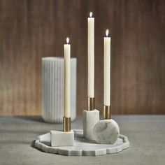 three candles are sitting on a marble stand