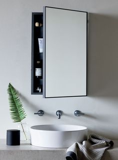 a white sink sitting under a bathroom mirror