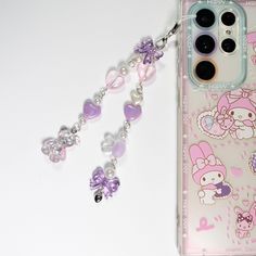 an iphone case with charms attached to it