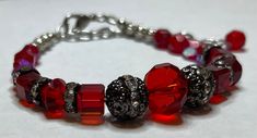 Beautiful red crystal glass beads paired up with metal beads with rhinestones  Measures 7.25" long with a 2" extension. Will be sent to you in a gift box. Strings are reenforced with end enforcers for less chance of breaking from wear. Silver Beaded Crystal Bracelet For Valentine's Day, Valentine's Day Silver Beaded Crystal Bracelet, Adjustable Red Bracelet With Rhinestones, Crystal Beaded Bracelets With Round Beads For Gifts, Crystal Beaded Bracelets As Gift, Crystal Beaded Bracelets For Gifts, Metal Crystal Bracelet For Gift, Valentine's Day Adjustable Crystal Bracelet, Nickel-free Red Beaded Bracelet As Gift