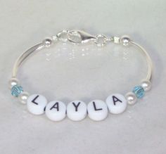 "An adorable gift for any newborn, this bracelet can be made in silver or gold and can have the child's birthstone between two white pearls on each side of the name. The bracelet can be as small as 4.5\" but can be made larger for an older girl or I can add a 1\" extension with a matching crystal or pearl on the end. Price is for up to 6 letters. The crystals are 4mm Swarovski crystal bicones and the pearls are 4mm Swarovski pearls (available in any color). The clasp is a lobster clasp. Please s Adjustable White Bracelet For Anniversary, White Hypoallergenic Name Bracelet For Anniversary, Hypoallergenic White Name Bracelet For Anniversary, White Hypoallergenic Bracelets As Gift, Hypoallergenic White Bracelets As Gift, Personalized Adjustable Beaded Bracelets For Birthday, Adjustable Hypoallergenic Round Name Bracelet, Adjustable Hypoallergenic Name Bracelet, Adjustable White Jewelry For Anniversary