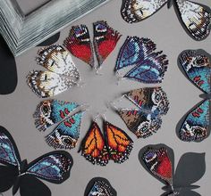 a group of butterflies sitting on top of a table next to a framed photo and two frames