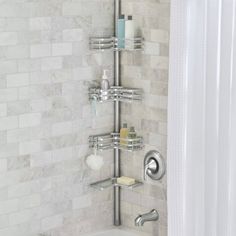 a bathroom with a shower and white tile walls