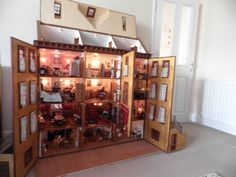 the doll house is made out of wood and has many mirrors on it's sides