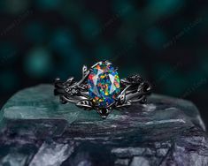 a ring that has been set on top of a rock with colorful stones in it