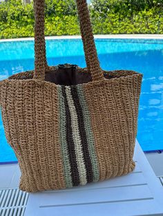 a brown bag sitting on top of a table next to a swimming pool