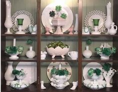 a shelf filled with lots of white and green dishes