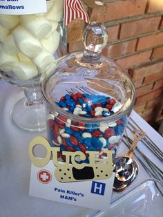 a glass jar filled with lots of candy on top of a table next to a flag