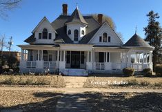 a large white house sitting on the side of a road