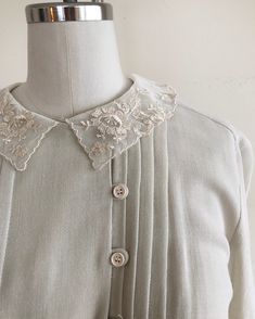 "Long-sleeved, ivory dress with pintucks and embroidered lace collar, from the 1980s. Bust measures 19\" (48.5 cm) flat across and waist measures 12-17.5\" (30.5-44.5 cm) flat across. The dress is 45\" (114 cm) in length. Original size is an 11. Cotton blend." Cream Long Sleeve Vintage Dress, Elegant Vintage Dress With Lace Collar For Vintage Events, Elegant Cream Vintage Dress For Daywear, Vintage Formal Dress With Peter Pan Collar, Vintage Cream Dress With Doll Collar, Vintage Dress With Peter Pan Collar For Daywear, Spring Vintage Cream Dress For Formal Occasions, Vintage Beige Dress With Lace Collar, Cream Vintage Dress For Spring Formal