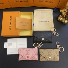 four louis vuitton wallets and keychains are on the table next to each other