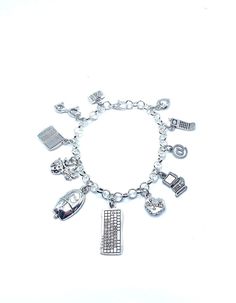 a silver bracelet with charms on it and a key to the door in the middle