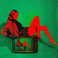 a woman sitting on top of a tv next to a man