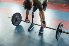 a man is lifting a barbell in a gym