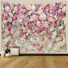 a wall with flowers on it in the middle of a wood flooring area and a vase