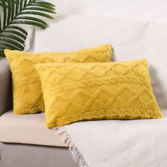 two yellow pillows sitting on top of a couch