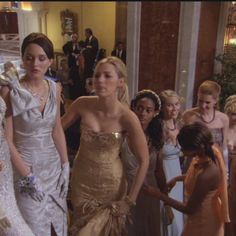 two women in dresses are standing next to each other and one woman is holding a bouquet