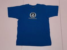 "Vintage 90's skateboarding/snowboarding brand VOLCOM front logo blue single stitch tee. Most probably made/assembled in Mexico (as most of the Volcom shirts with the same tag). It is pre-used and in good vintage condition. Size on label: M as medium. Please compare your measurements with the measurements provided below before buying this item. Length from center back: 64 cm / 25.20\" inches Chest: 52 cm / 20.47\" inches Sleeve Length, from arm opening: 21 cm / 8.27\" inches Material: Tag remove Blue T-shirt With Logo For Streetwear, Blue Logo T-shirt For Streetwear, Volcom Logo, Label M, Karl Kani, Surf Style, Blue Jacket, Estonia, Favorite Shirts