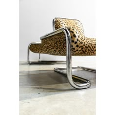 an animal print chair sitting on top of a metal frame