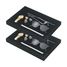 three pairs of sunglasses are sitting in a black box with diamond trimming around them