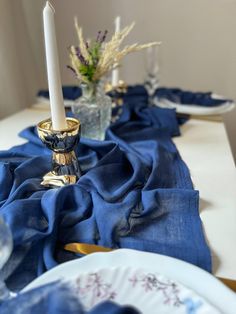 the table is set with blue cloth and gold candlesticks