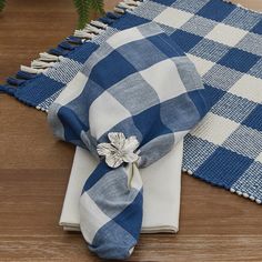 a blue and white checkered table cloth with a flower on it