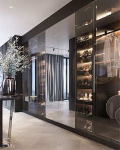 a walk in closet filled with lots of shoes and bags next to a vase full of flowers