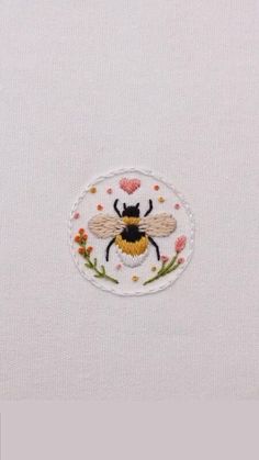 embroidered bee on white fabric with flowers