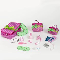 the contents of a doll's pink and green bag are laid out on a white surface