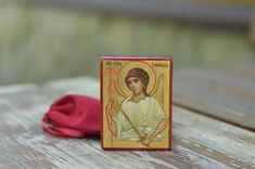 a small wooden box with an image of jesus holding a cross on it's side