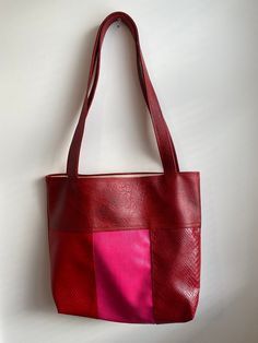 Unique handmade faux-leather tote bag in red and pink.  Bag measures 15 inches wide x 16 inches tall Total height including strap is 28 inches Cotton lining. Features two interior pockets Large Capacity Red Faux Leather Bag, Red Faux Leather Satchel, Red Faux Leather Travel Bag, Red Faux Leather Travel Shoulder Bag, Red Faux Leather Shoulder Bag With Double Handle, Red Rectangular Faux Leather Bag, Red Faux Leather Shoulder Bag For Travel, Red Square Bag For Daily Use, Pink Hobo Bag With Removable Pouch For Shopping