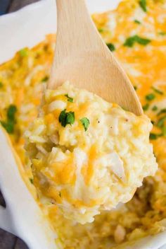 a wooden spoon scooping out some food from a casserole dish with rice