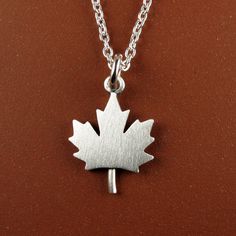 "This little maple leaf is made of sterling silver.  The pendant is quite TINY, measuring just under 5/8\" (1.5 cm) from top to bottom.  Perfectly simple and a perfect symbol of Canada! You can purchase just the pendant/charm, or complete the necklace with a sterling silver chain.  We also make matching maple leaf earrings:  www.etsy.com/ca/listing/970830486/tiny-maple-leaf-earrings © Stick Man Creations This is our own original design, handcrafted by us, and signed on the back with our logo.   For more information about the creative process, click here:  www.etsy.com/shop/StickManJewelry/about CANADIAN ORDERS:  Please note that GST and HST are included in the price, but provincial taxes are not." Stick Man, Silver Box, Leaf Pendant, Necklace Sterling Silver, Leaf Earrings, Box Chain, Sterling Silver Chain, Creative Process, Maple Leaf