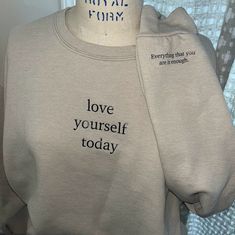 Love Yourself Today crew has a cute detail on the left sleeve that is a message to the person wearing the sweatshirt. This small detail serves as a reminder to the person wearing it. Spread positivity into this world with this crewneck. Comes in multiple colors, can be dyed with bleach as well. Color in main photo is Tan/Beige.  The last few years have been incredibly tough on people everywhere mentally. The goal of IPOY's clothing is to make those struggling feel as though they are not alone, someone somewhere is rooting for them.  The purpose of my clothing is to not only help those wearing it, but also the loved ones and strangers who read it also.  IPOY stands for I'm proud of you; and truly I am. My name is Allison and I started IPOY in 2021 during a difficult time in my life and I ca Everyday Crew Neck Sweatshirt With Embroidered Text, Everyday Crew Neck Sweater With Letter Print, Everyday Relaxed Fit Sweatshirt With Embroidered Text, Inspirational Text Print Sweatshirt For Fall, Inspirational Long Sleeve Sweatshirt With Text Print, Inspirational Slogan Sweatshirt For Fall, Everyday Crew Neck Sweats With Letter Print, Everyday Long Sleeve Sweats With Letter Print, Inspirational Text Print Fall Sweatshirt