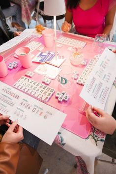 people are sitting at a table with letters and numbers on it while one person is writing