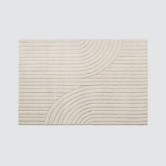 a white rug with wavy lines on the side and a circular design in the middle