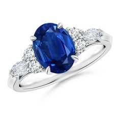 an oval blue sapphire and diamond ring with three stone side stones on the band, set in 18k white gold