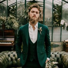 a man with a beard wearing a green suit