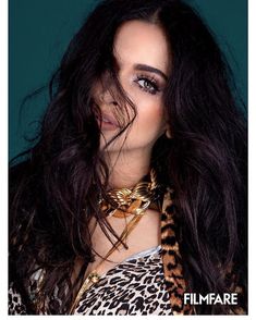 a woman with long black hair and leopard print shirt posing for a magazine cover photo