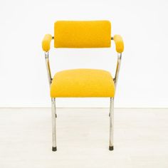 a yellow chair sitting on top of a hard wood floor